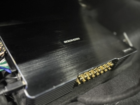 車内に設置された黒いAudison DSPユニットと端子部